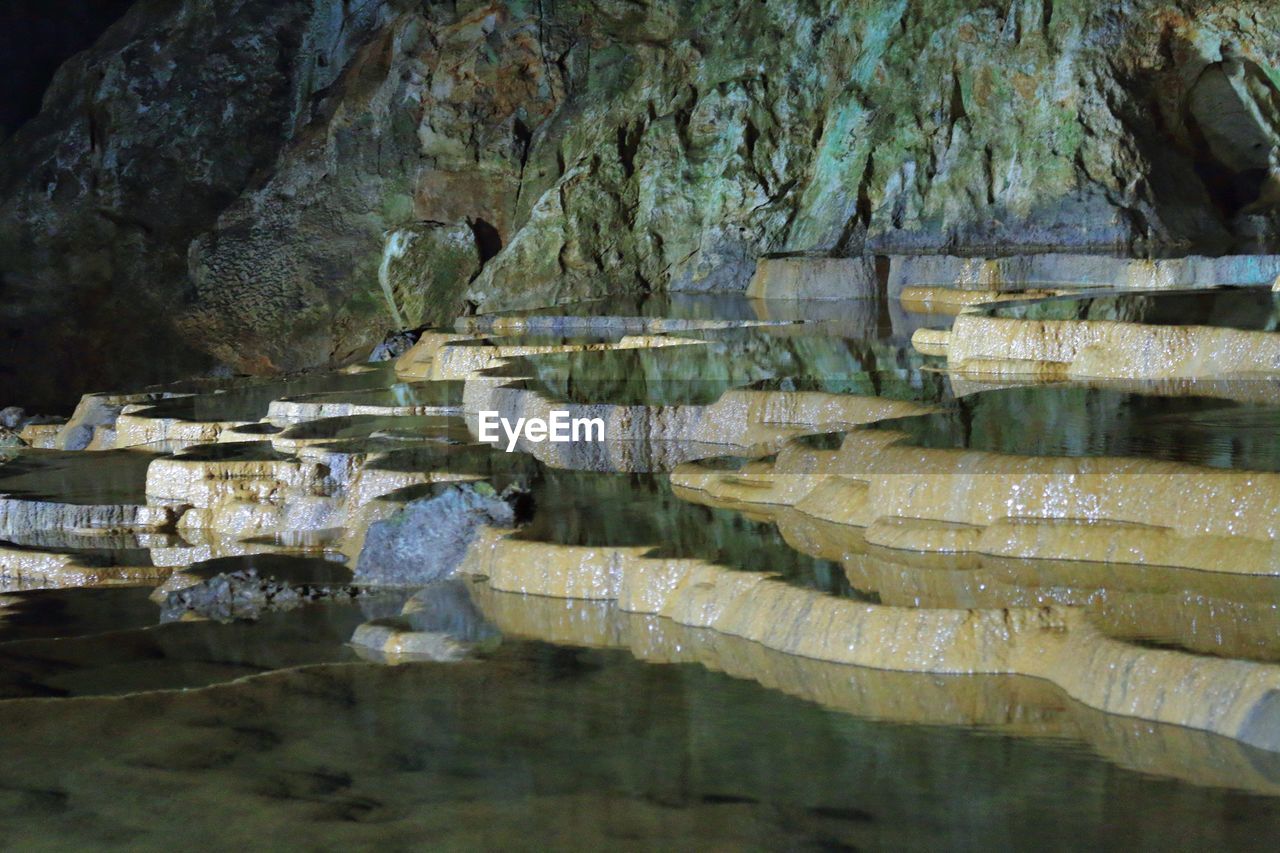 SCENIC SHOT OF ROCKS IN CALM WATER