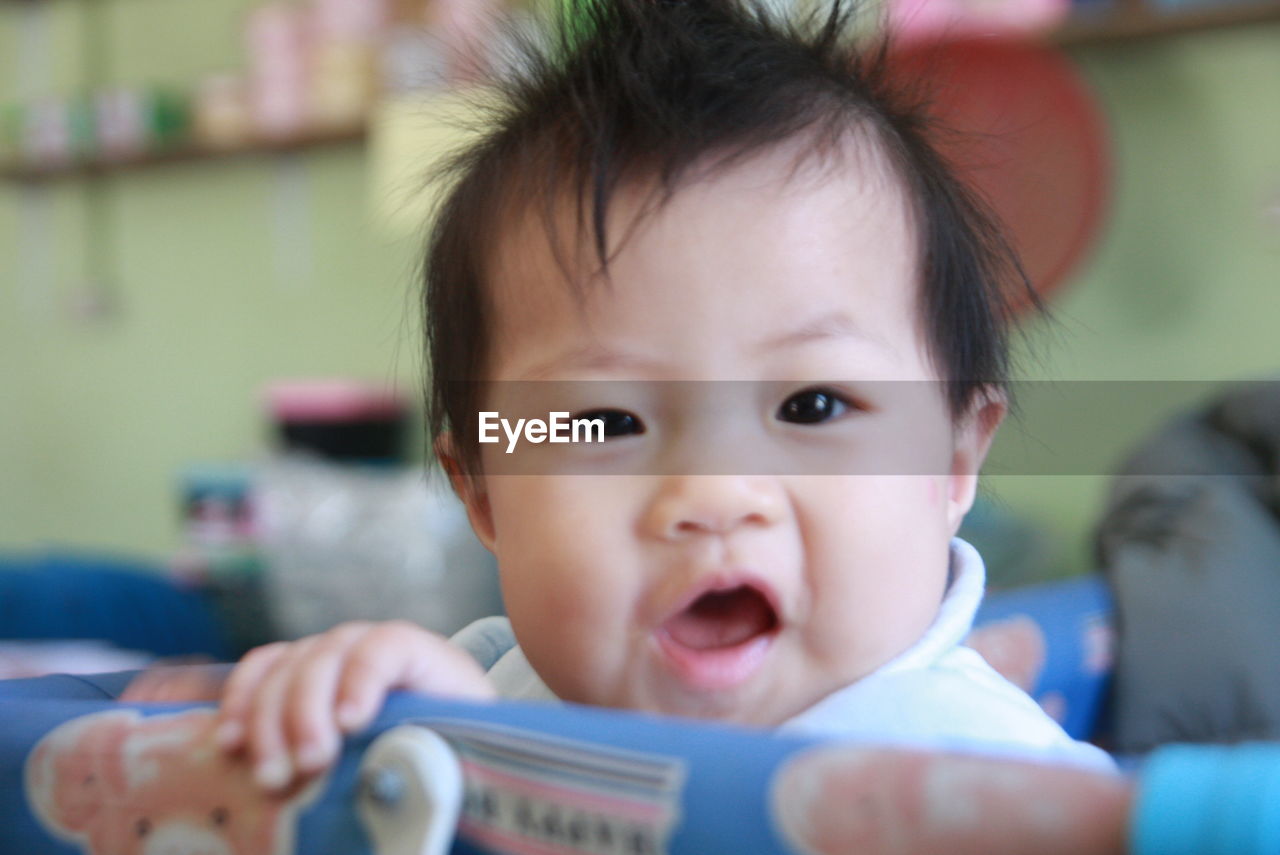 Close-up portrait of cute baby girl in crib at home