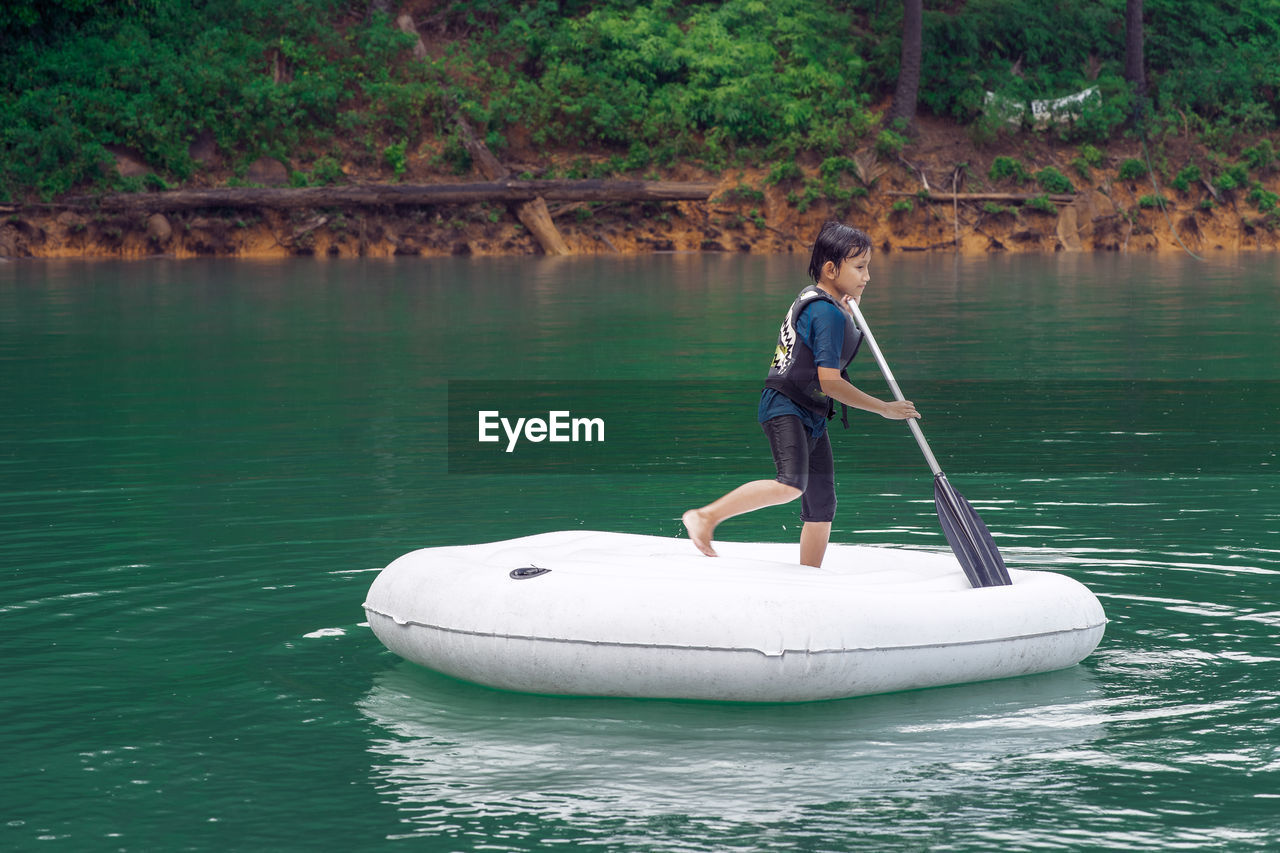 Boy sitting in boat on lake