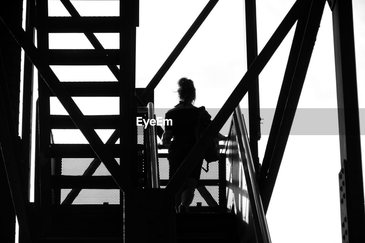 REAR VIEW OF SILHOUETTE MAN STANDING ON STAIRCASE