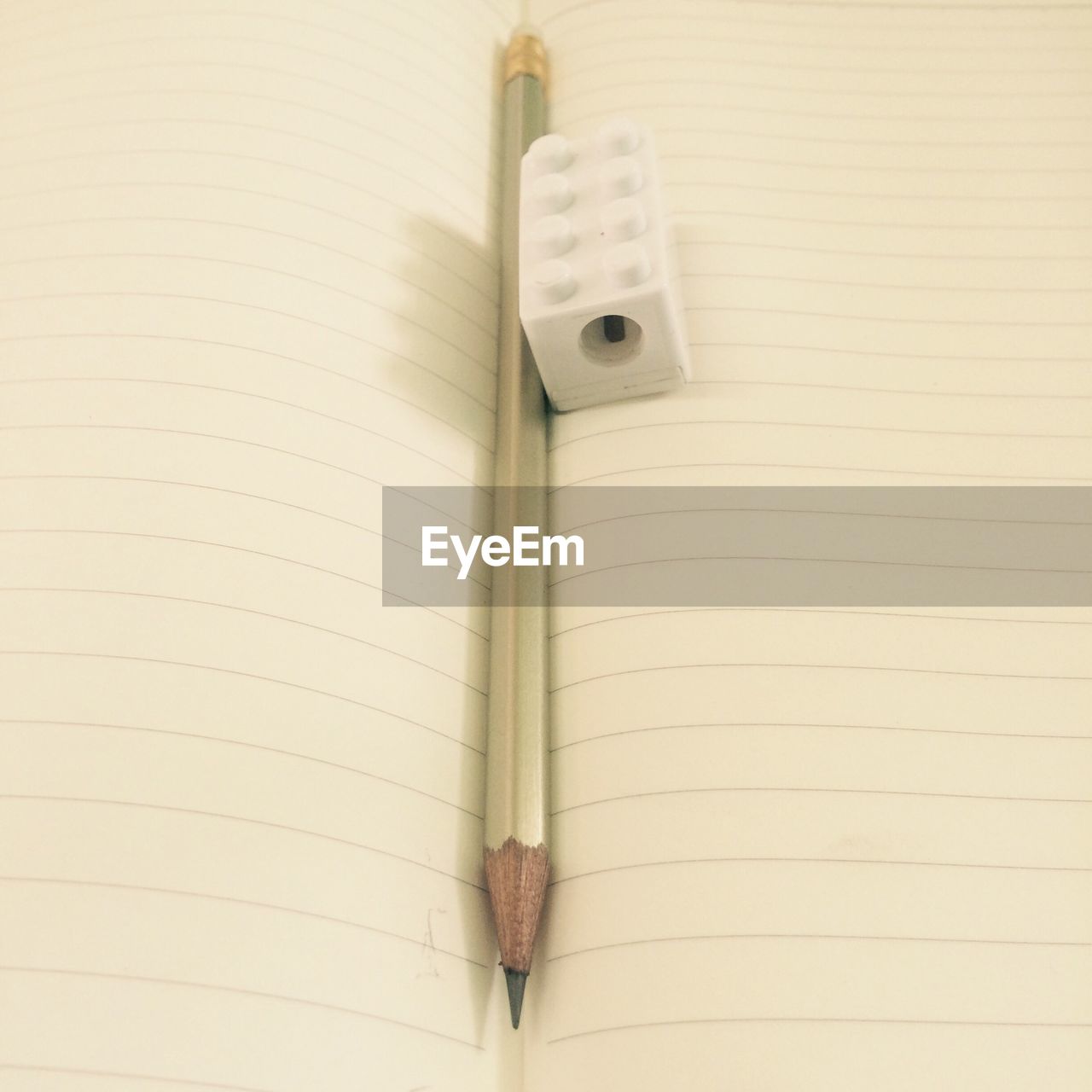 High angle view of pencil and sharpener on open book