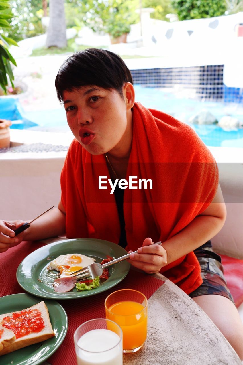 Portrait of woman having food while sitting at restaurant