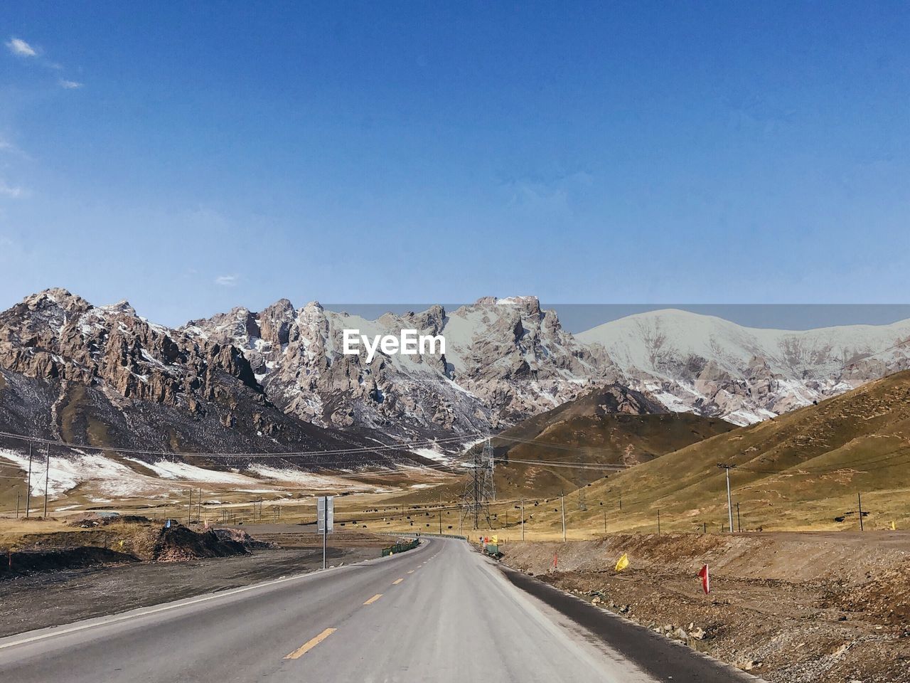 Road amidst snowcapped mountains against sky