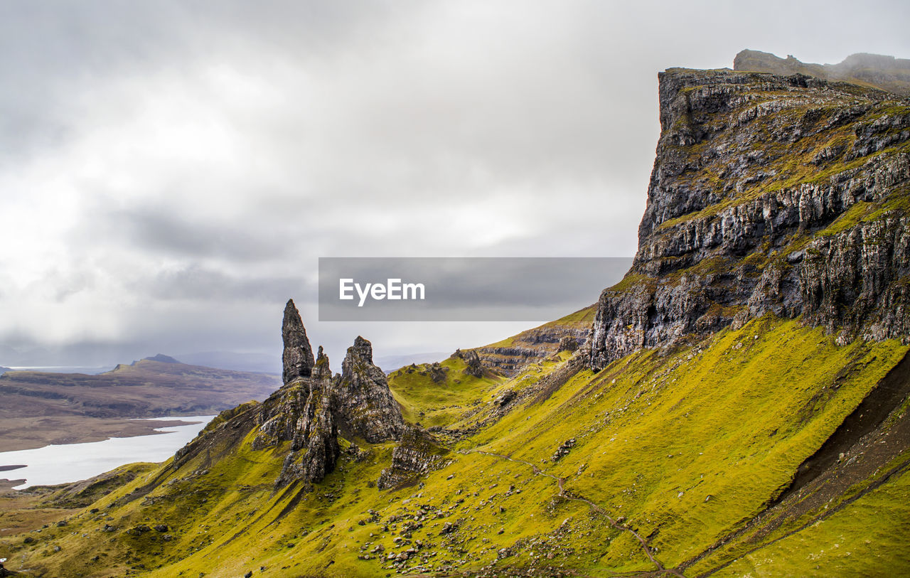 Scenic view of mossy mountain against sky