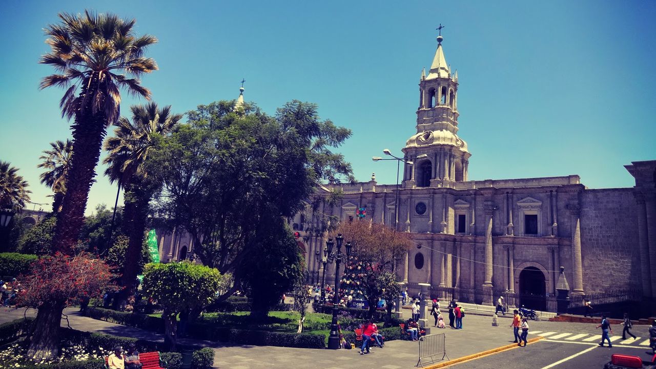 Tourists at basilica cathedral of arequipa against clear blue sky