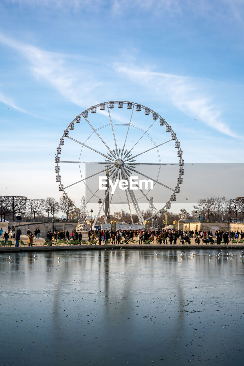 People by ferris wheel at amusement park