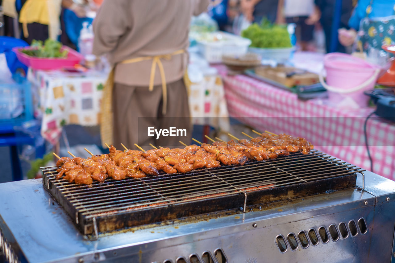 Meat cooking on barbecue grill in market