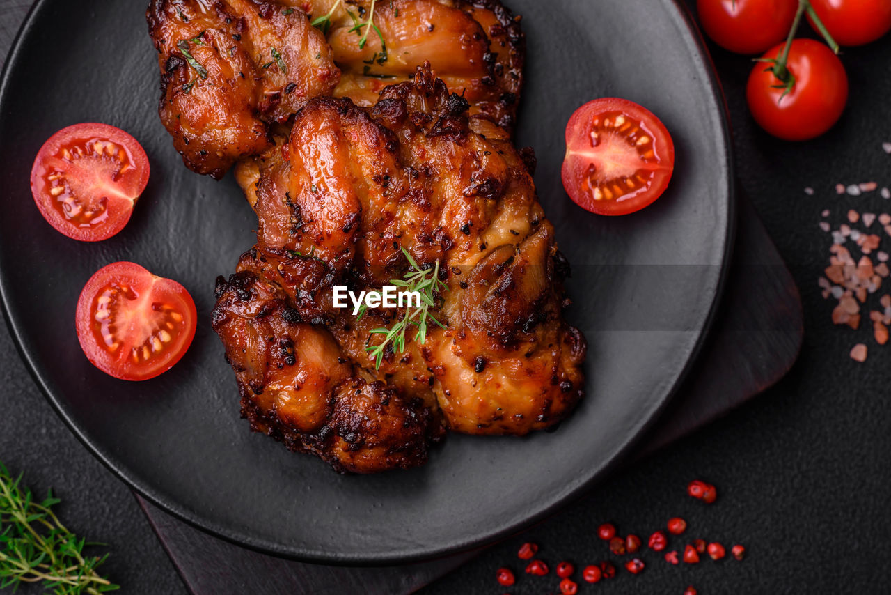 food and drink, food, meat, roasted, dish, tandoori chicken, herb, meal, vegetable, dinner, tomato, fried food, chicken, no people, freshness, produce, chicken meat, fruit, healthy eating, barbecue chicken, high angle view, spice, white meat, grilling, red, directly above, studio shot, barbecue, rosemary, wellbeing, gourmet, roast goose, plant, indoors, dark, cherry tomato