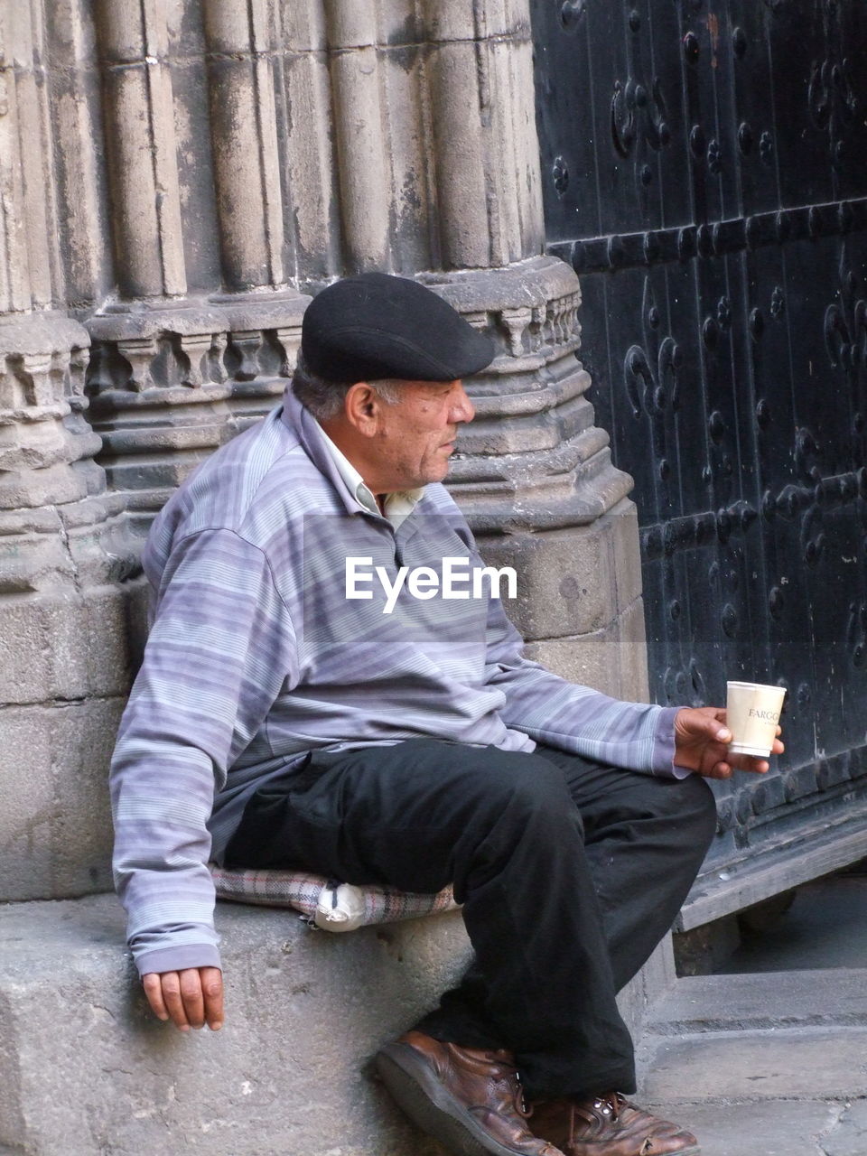 PORTRAIT OF MAN SITTING IN CITY