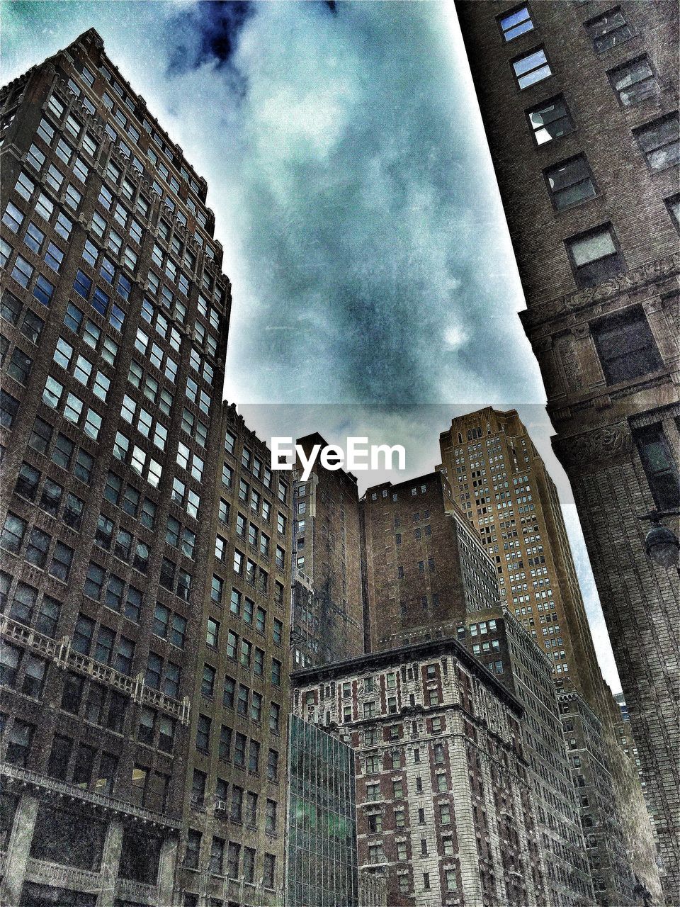 LOW ANGLE VIEW OF BUILDINGS AGAINST CLOUDY SKY