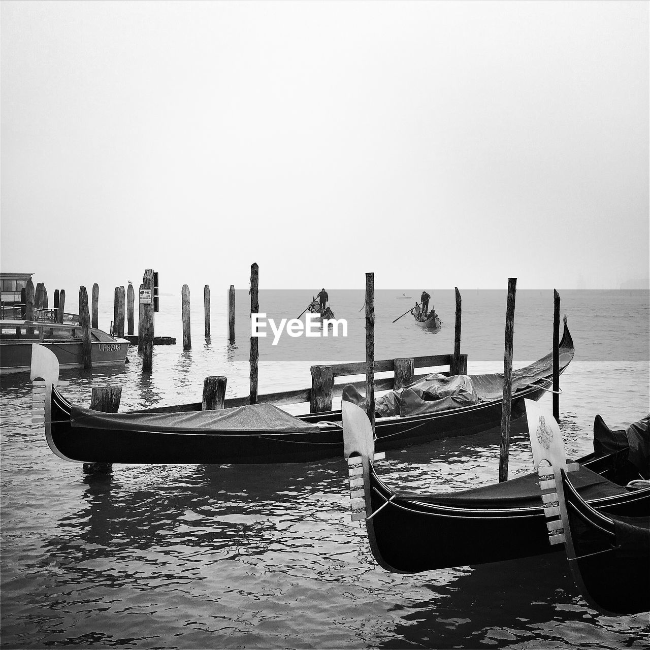 Moored boats in calm lake against clear sky