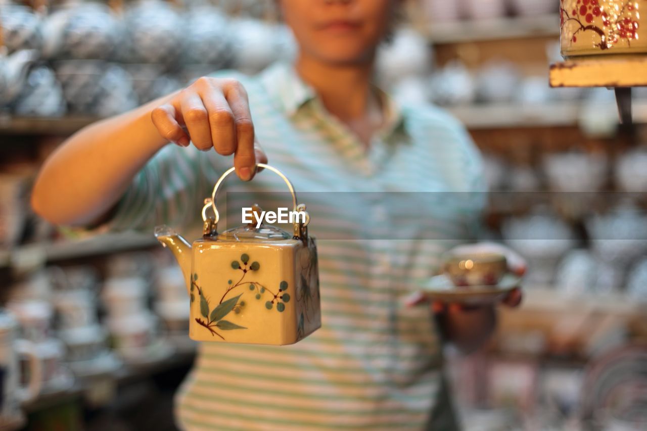 Woman holding teapot in store