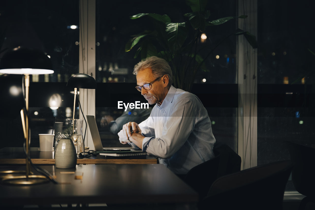 Dedicated senior male professional working late at creative workplace