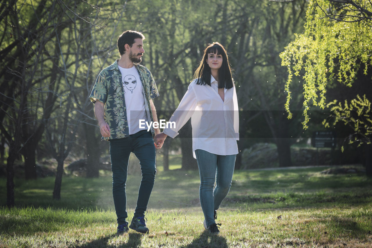 Couple walking hand in hand in park