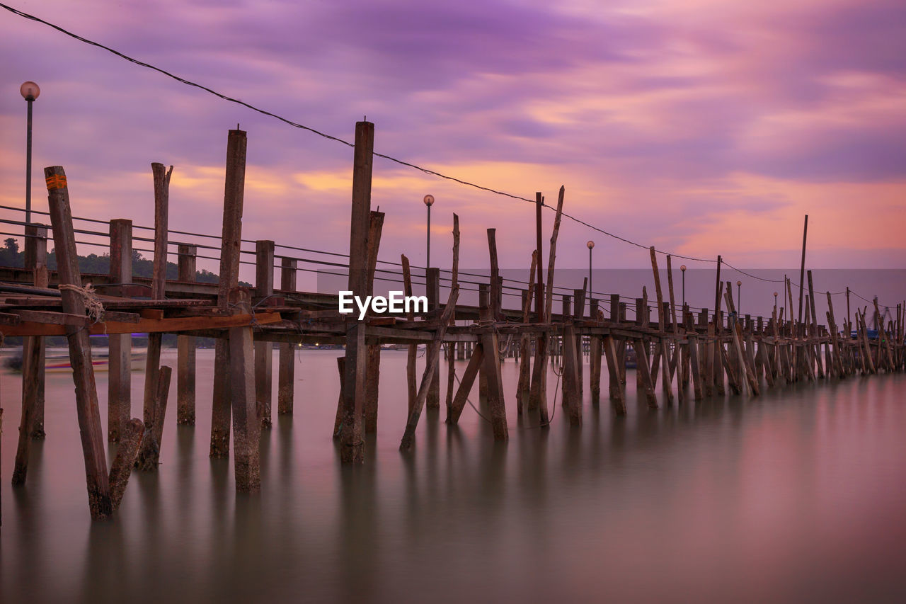 Pier over sea against sky during sunset