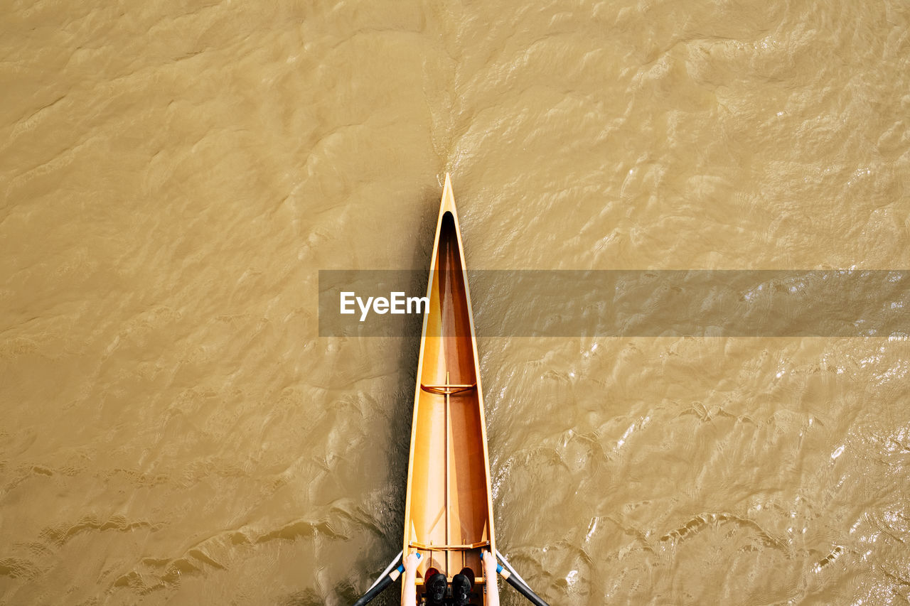 View from above on part of woman rowing single scull on river