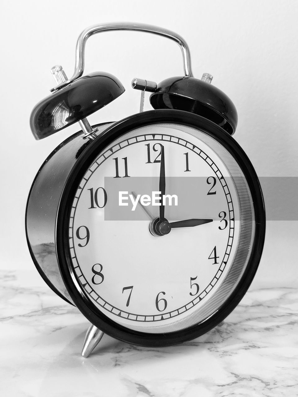 Close-up of alarm clock on table against gray background