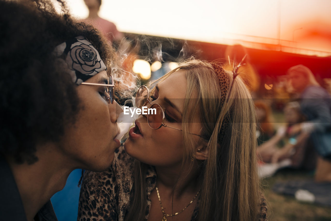 Close-up of couple smoking together at musical event