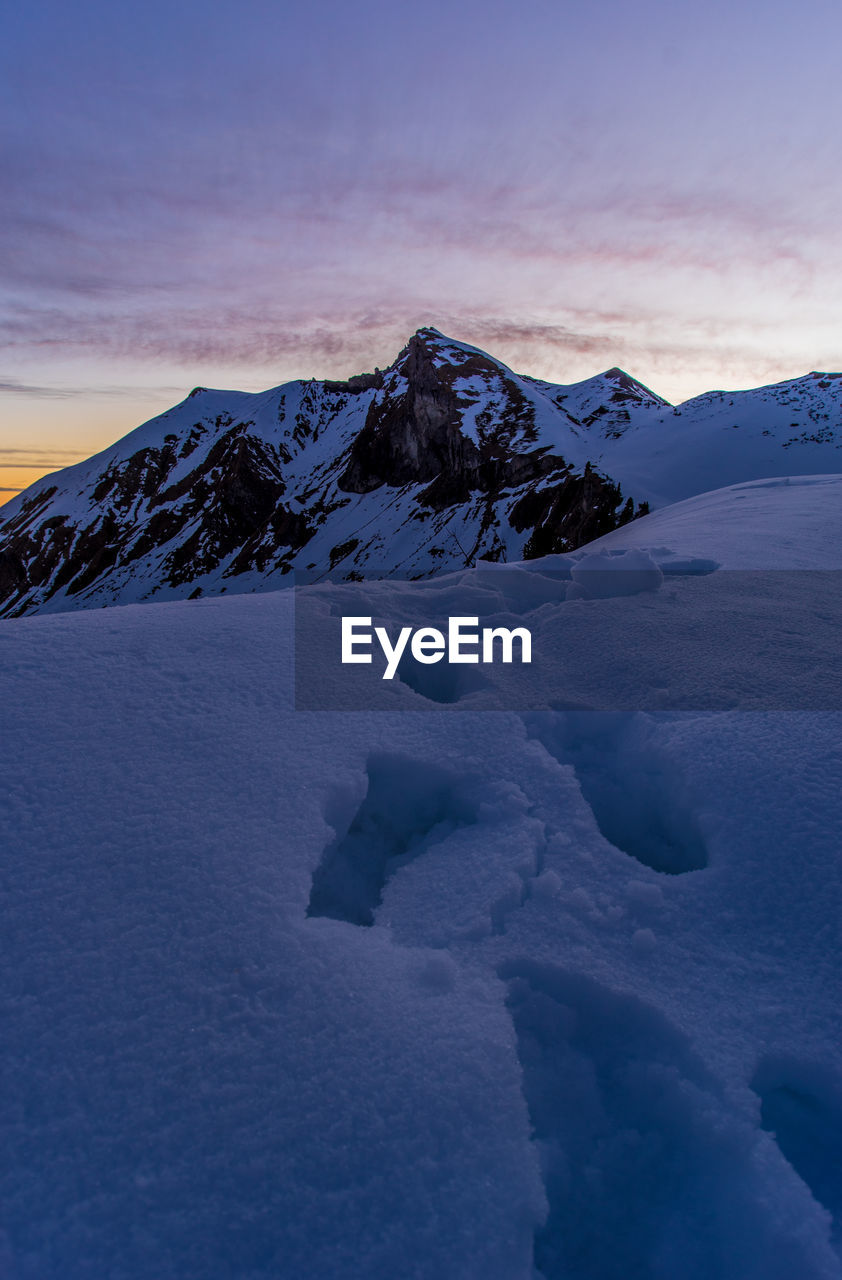 Scenic view of snow covered mountains against sky