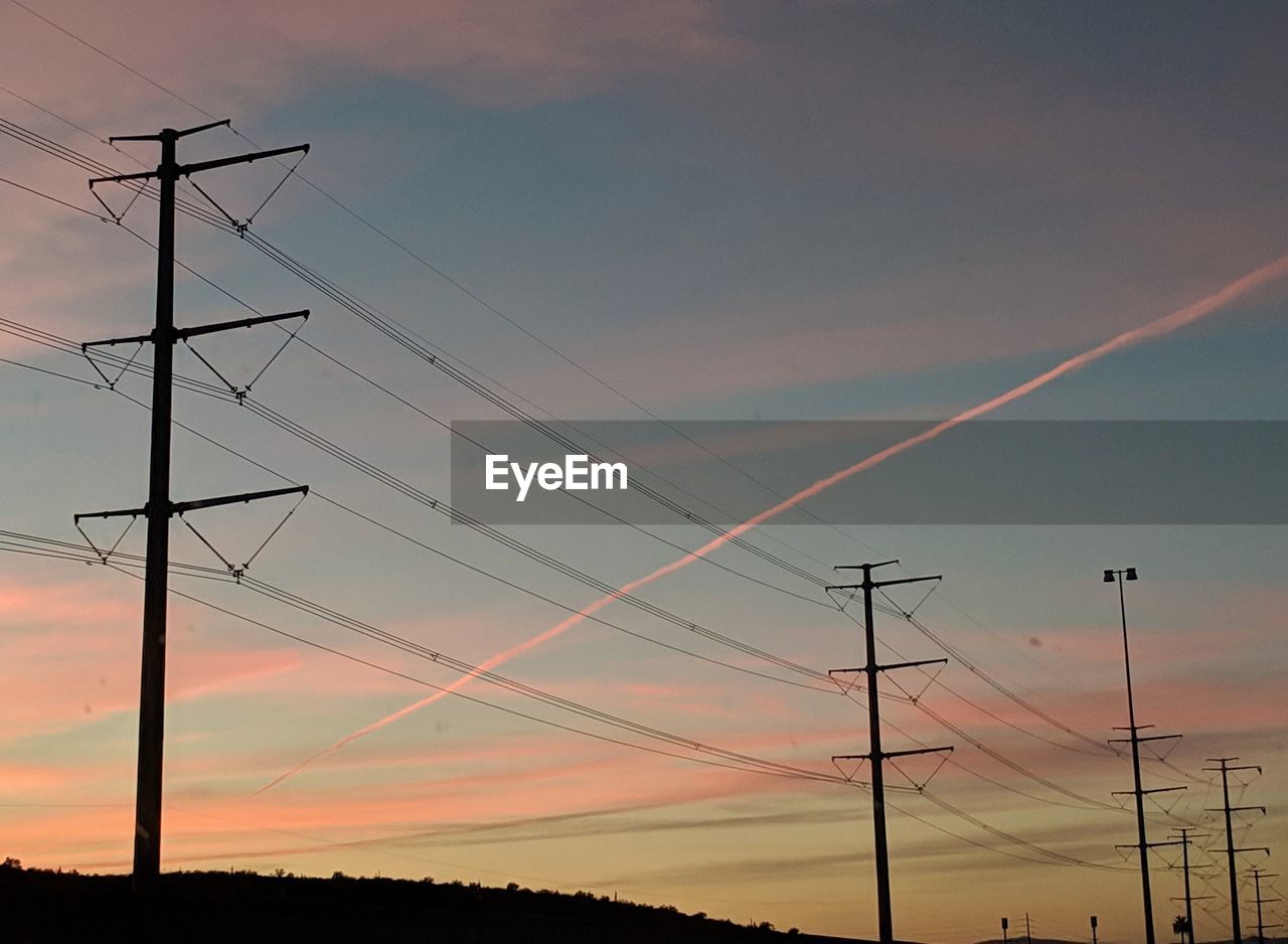 LOW ANGLE VIEW OF ELECTRICITY PYLONS AGAINST SKY DURING SUNSET