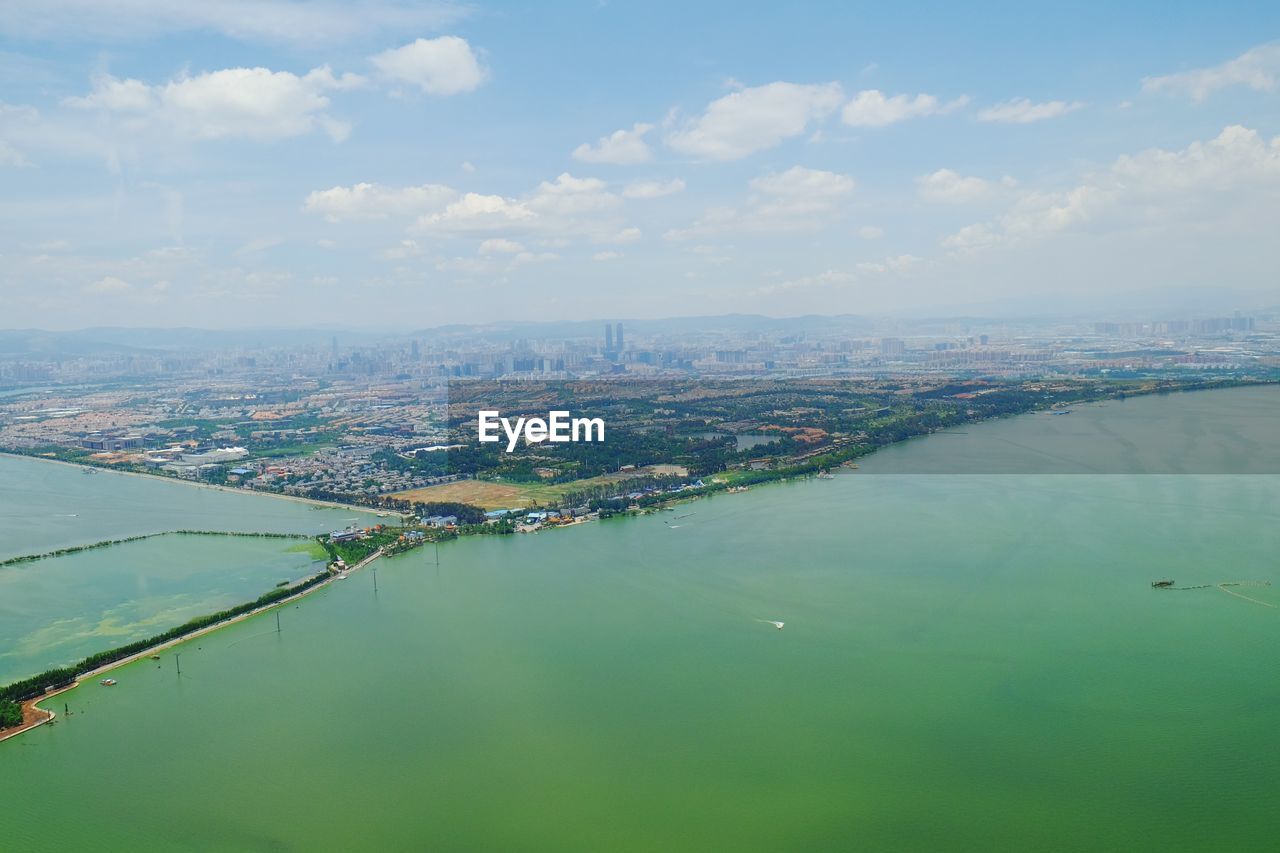 Aerial view of river against cloudy sky during sunny day