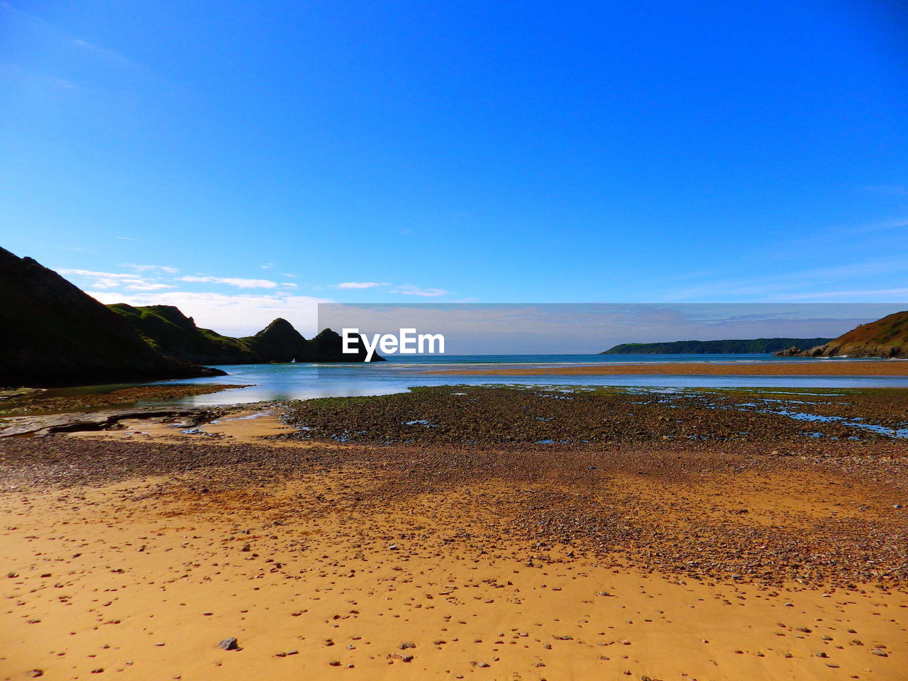 VIEW OF BEACH AGAINST BLUE SKY