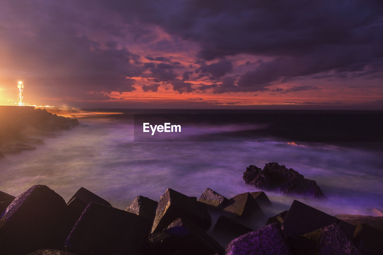 scenic view of sea against cloudy sky during sunset