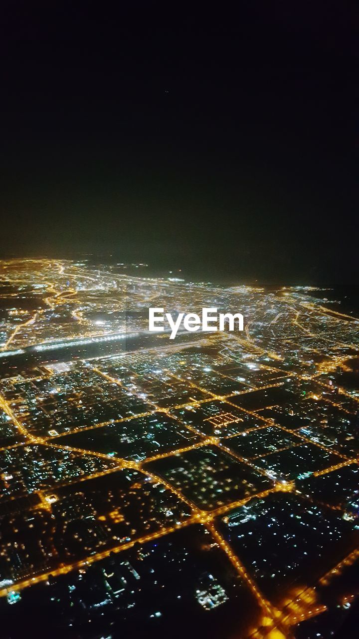 AERIAL VIEW OF ILLUMINATED CITYSCAPE AT NIGHT