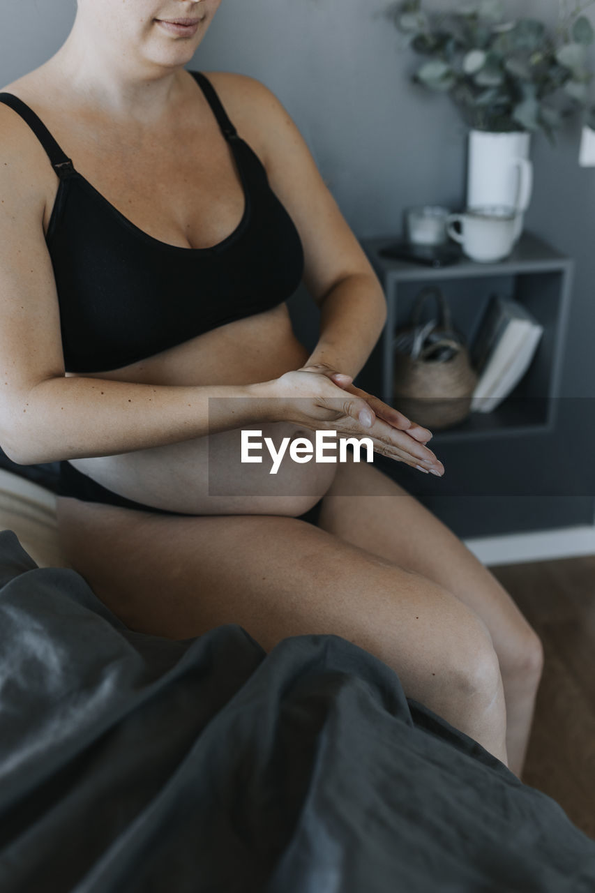 Pregnant woman doing body care routine