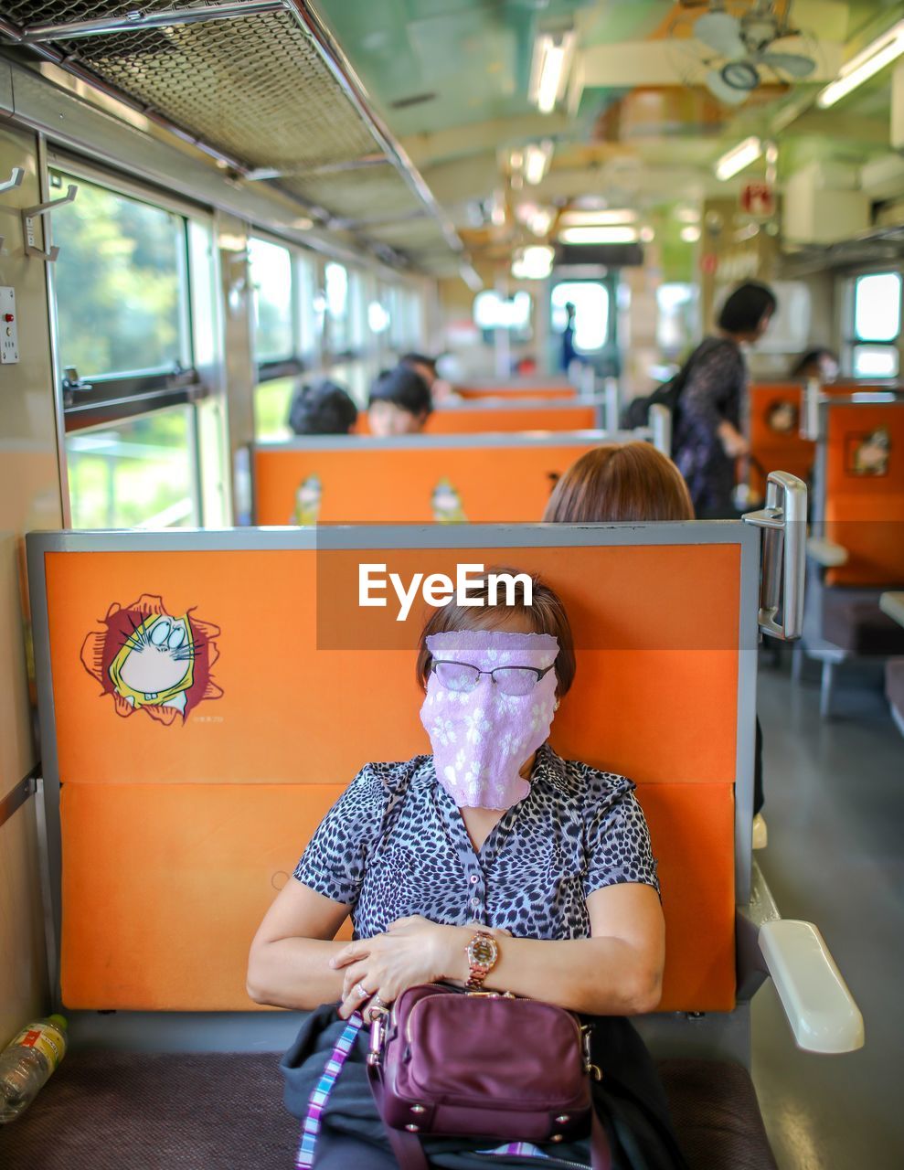 REAR VIEW OF WOMAN SITTING ON TRAIN