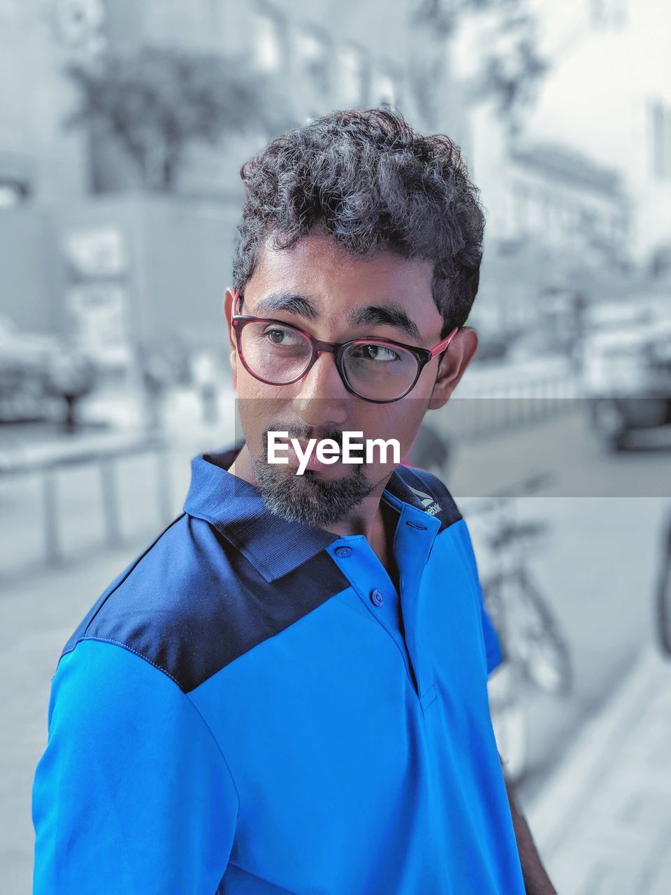 Smiling young man wearing eyeglasses standing outdoors