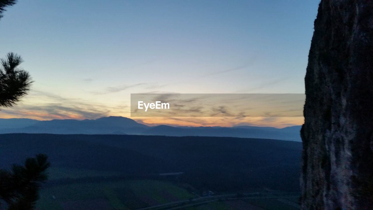 SCENIC VIEW OF MOUNTAINS AT SUNSET