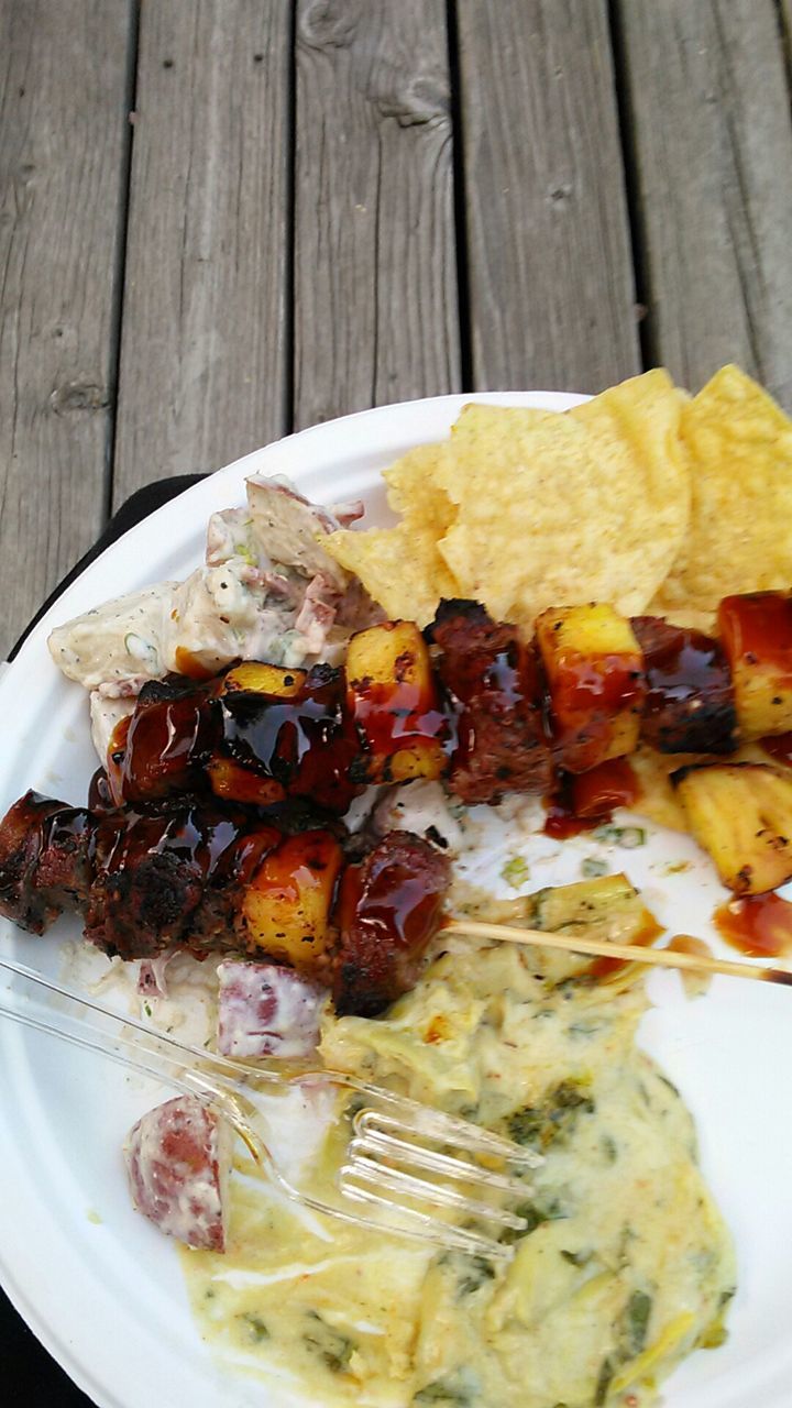 Close-up of meat in skewer and sauce on plate at table