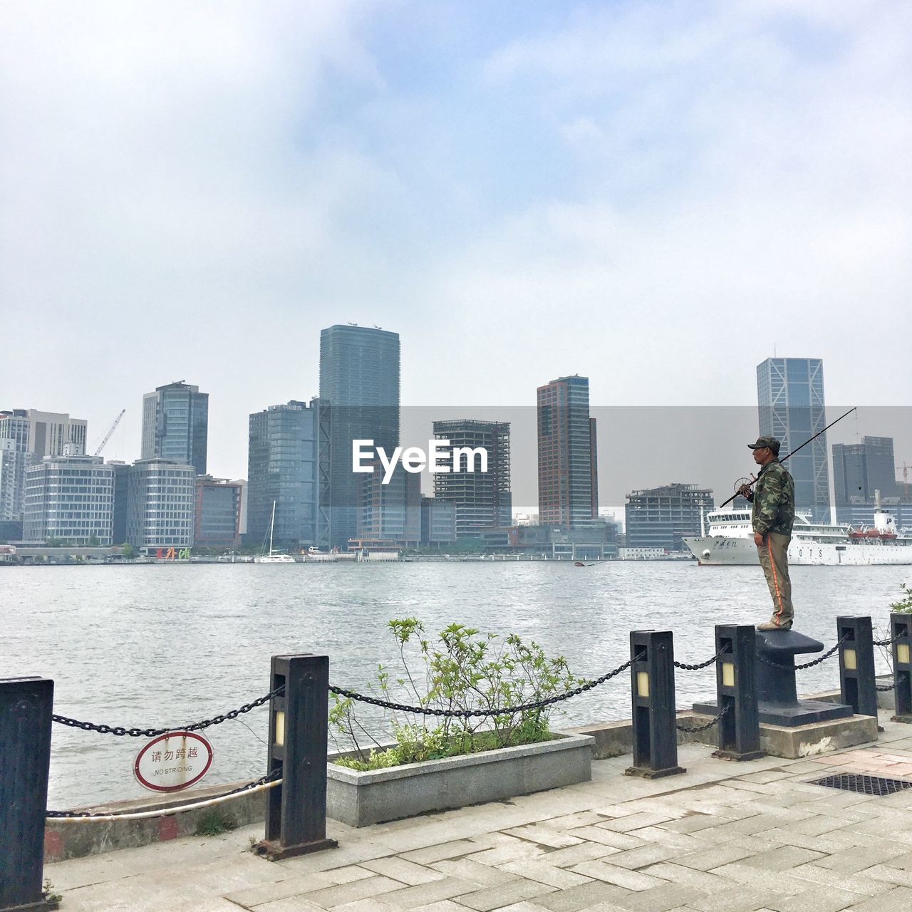 MAN WITH CITYSCAPE IN BACKGROUND AGAINST SKY