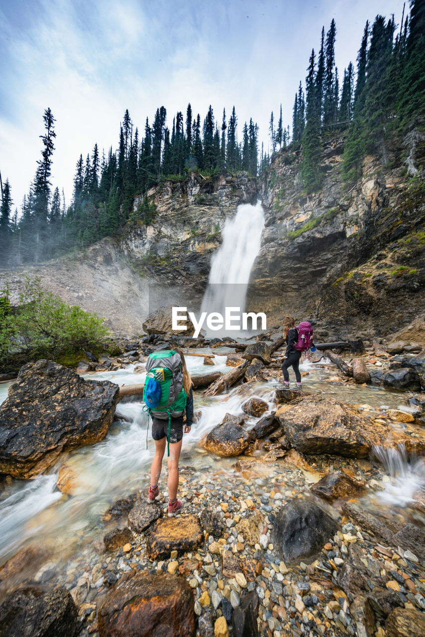 Hikers standing alongside laughing falls waterfall in yoho