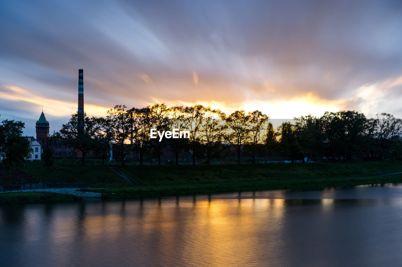 SCENIC VIEW OF RIVER BY TREES AGAINST SKY DURING SUNSET