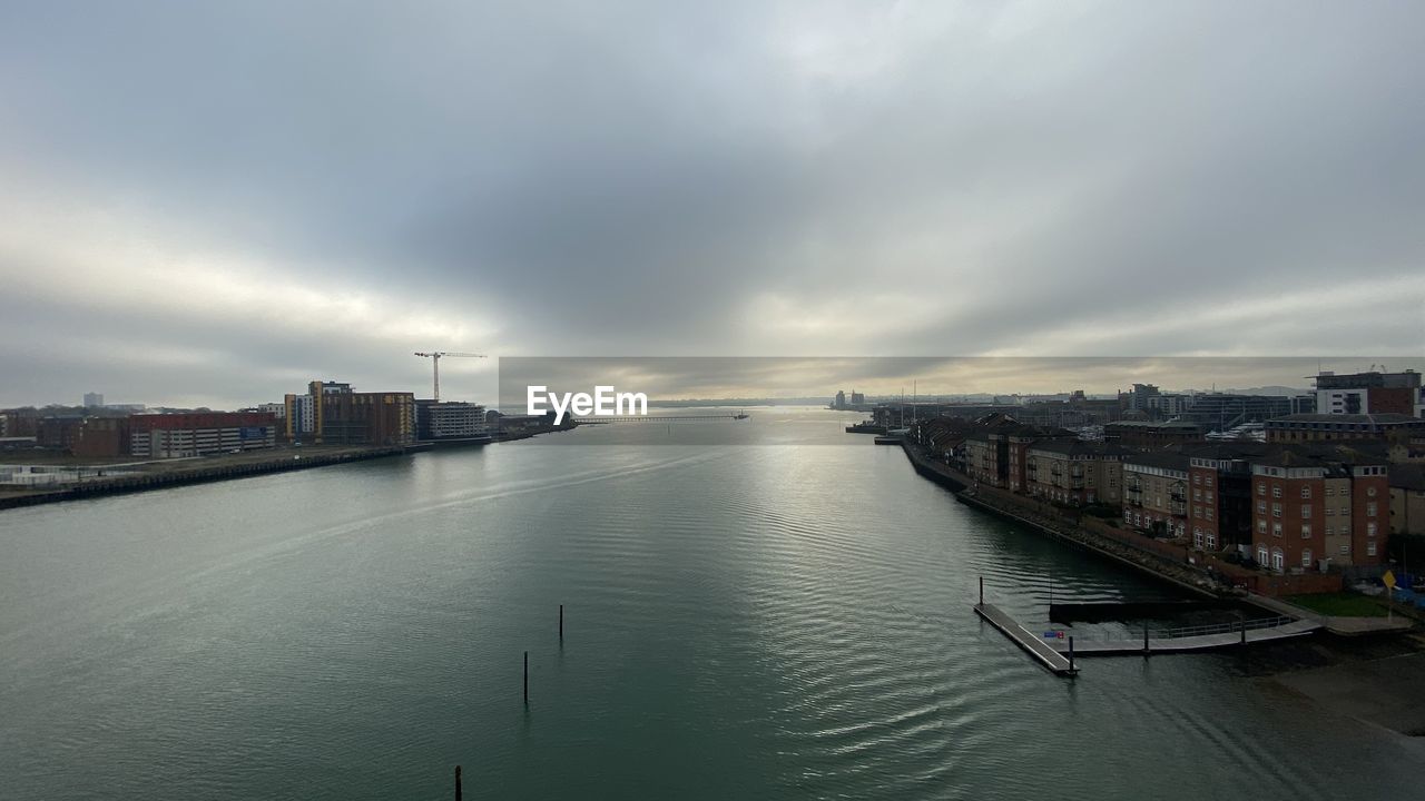 HIGH ANGLE VIEW OF RIVER BY BUILDINGS IN CITY