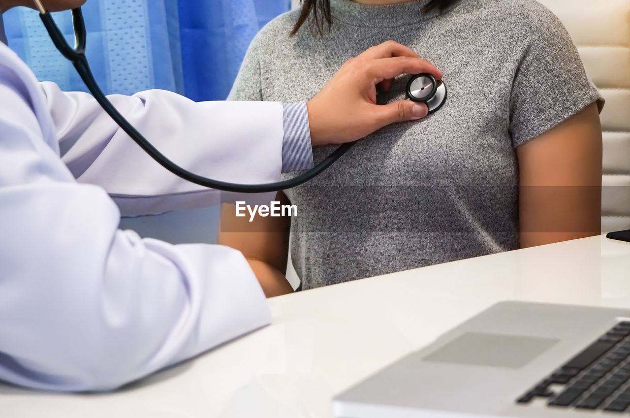 Midsection of doctor examining patient