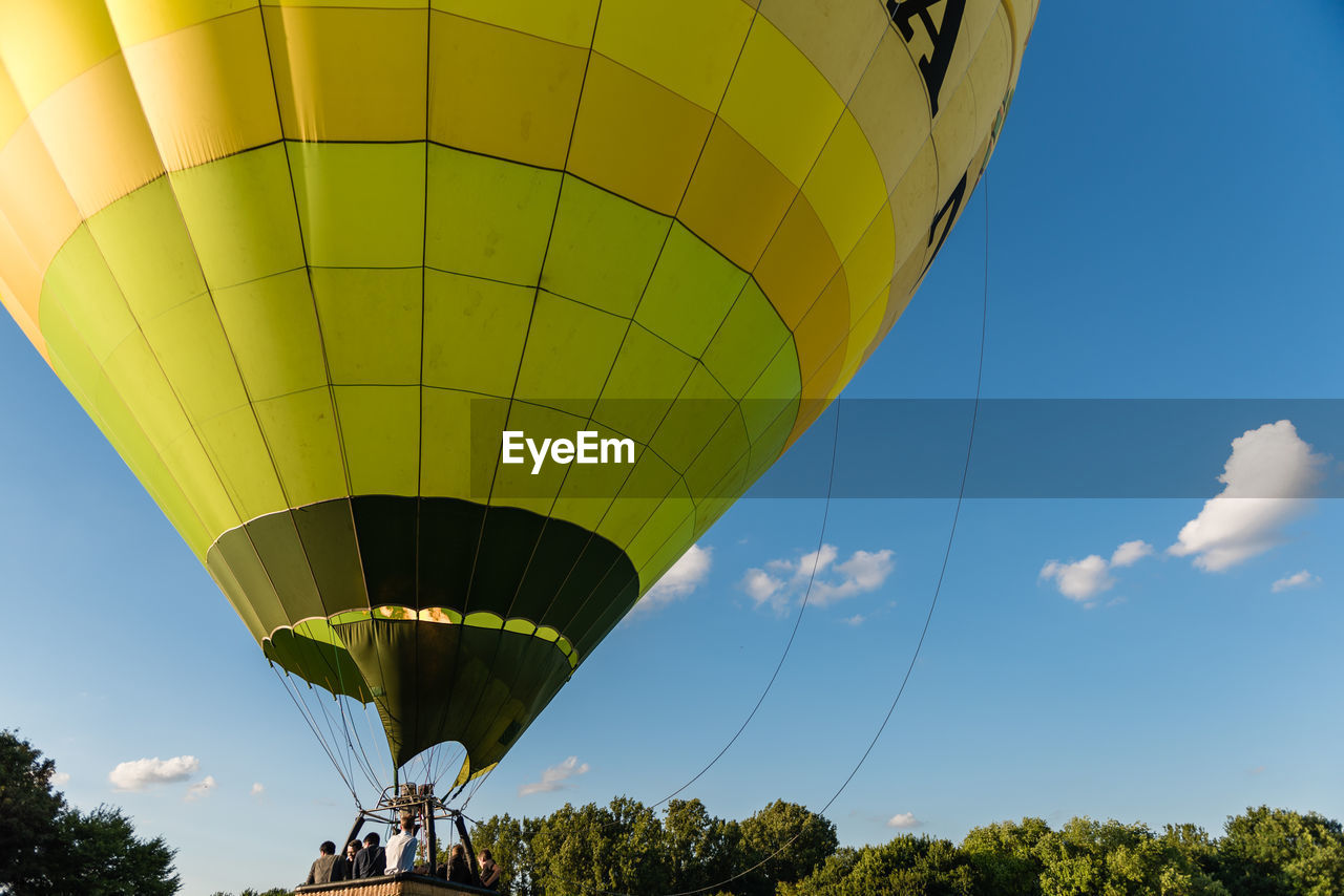 Low angle view of hot air balloon flying against blue sky