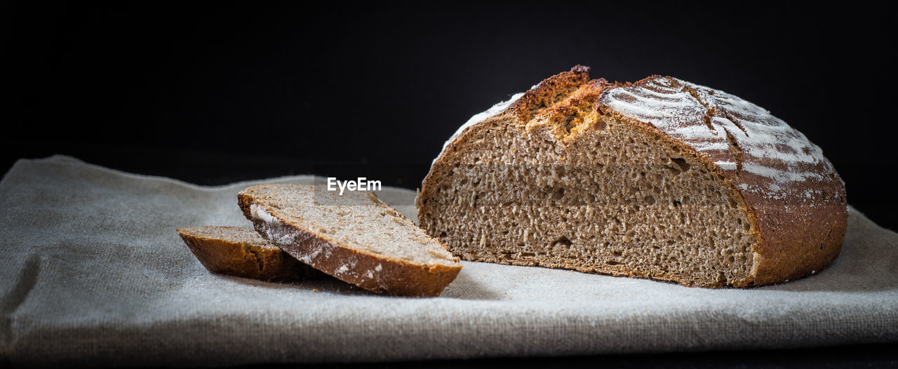 Close-up of bread on napkin against back background