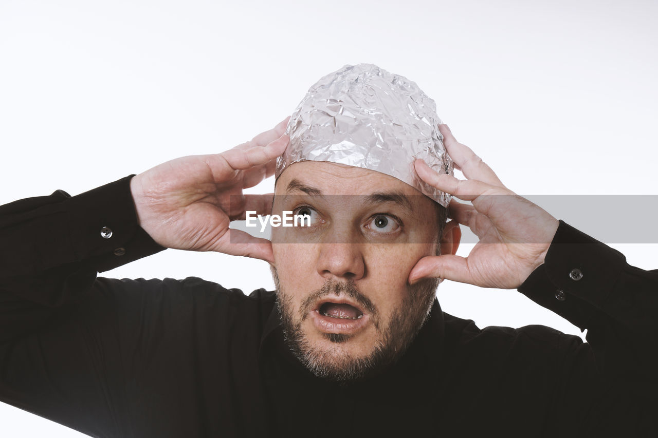 portrait, adult, one person, men, headshot, studio shot, indoors, white background, beard, looking at camera, looking, cap, business, facial hair, hand, clothing, emotion, person, young adult, front view, fashion accessory, facial expression, surprise, cut out, emotional stress, overworked, occupation