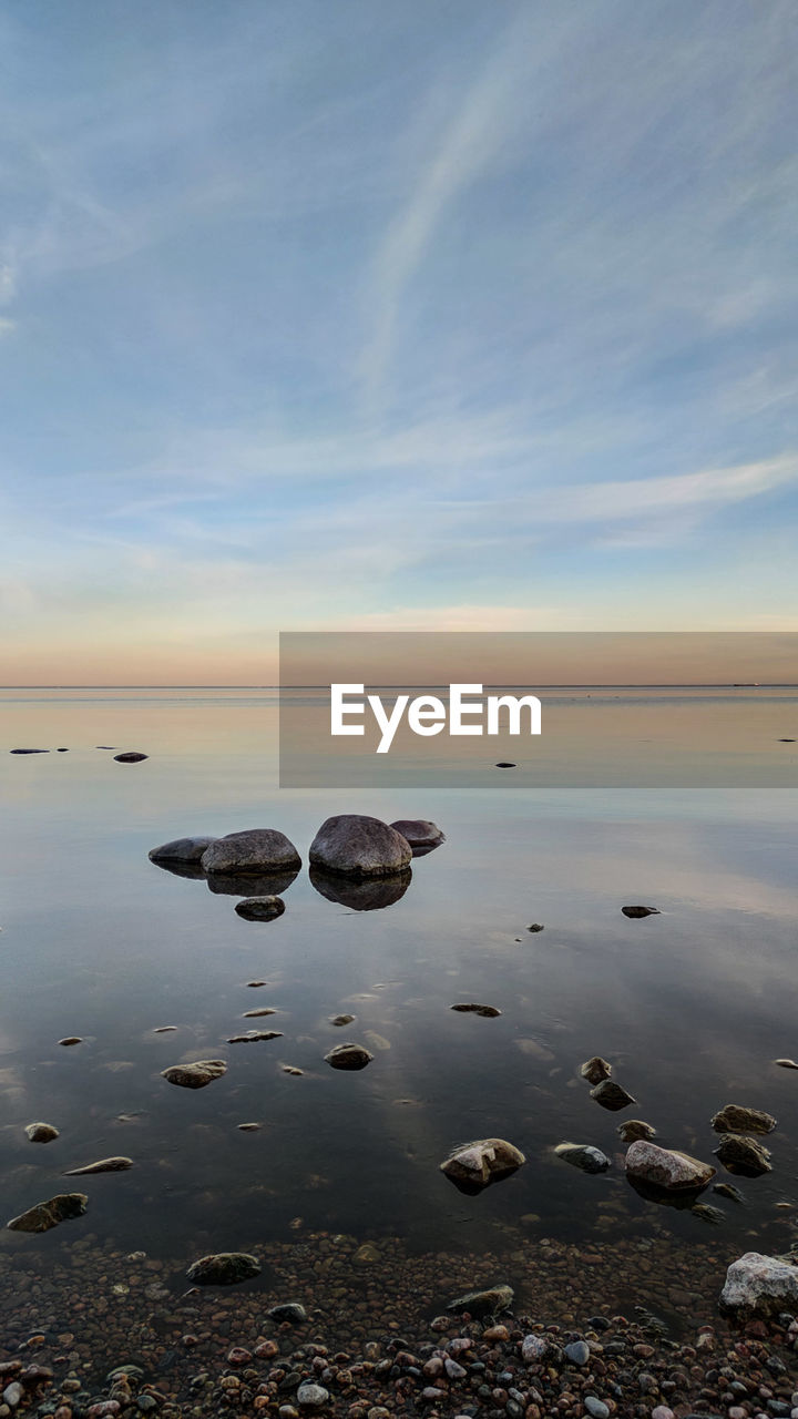 ROCKS IN SEA AGAINST SKY