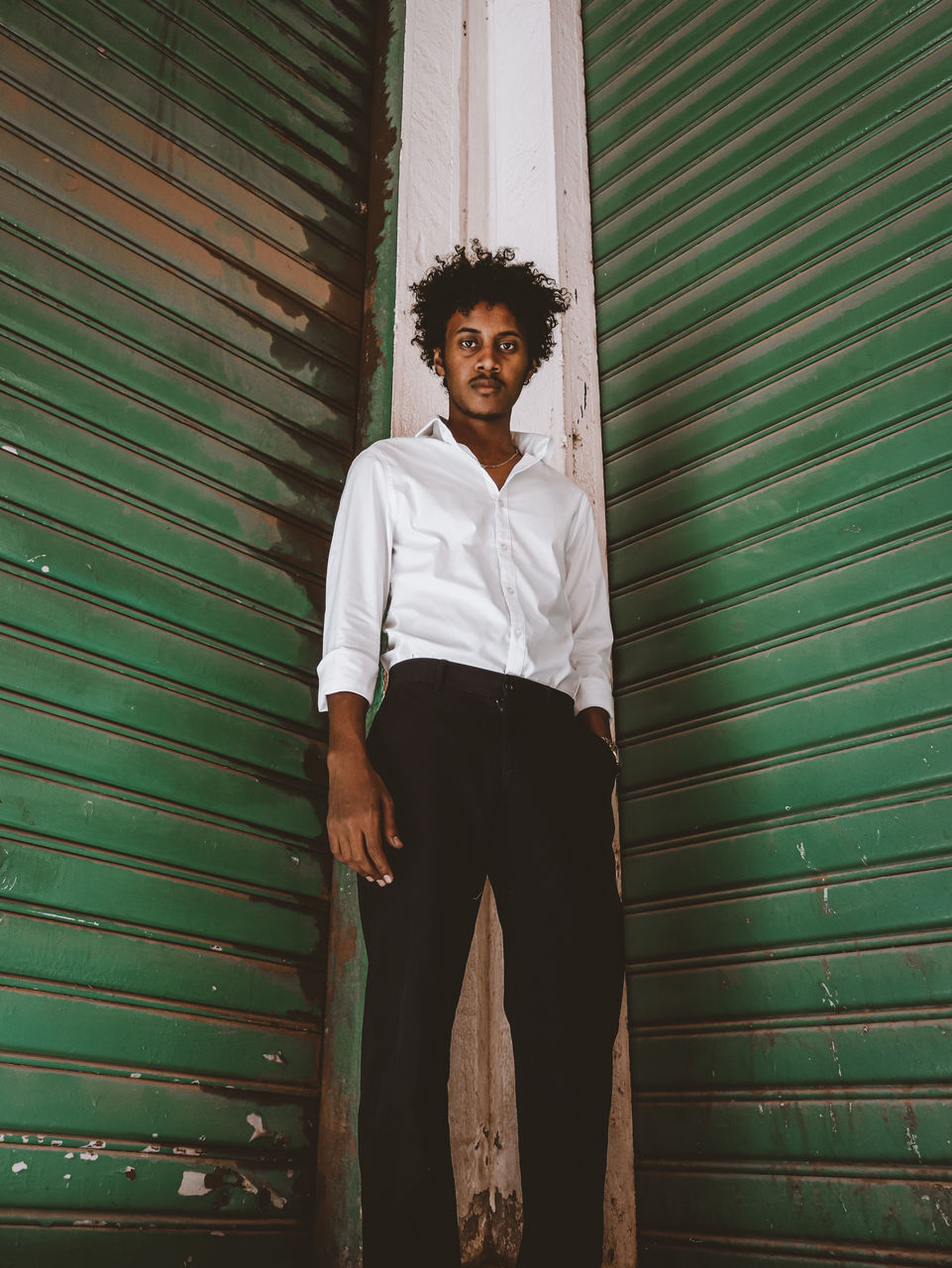 Portrait of young man sitting on wooden wall with the effect of a vintage old film camera 