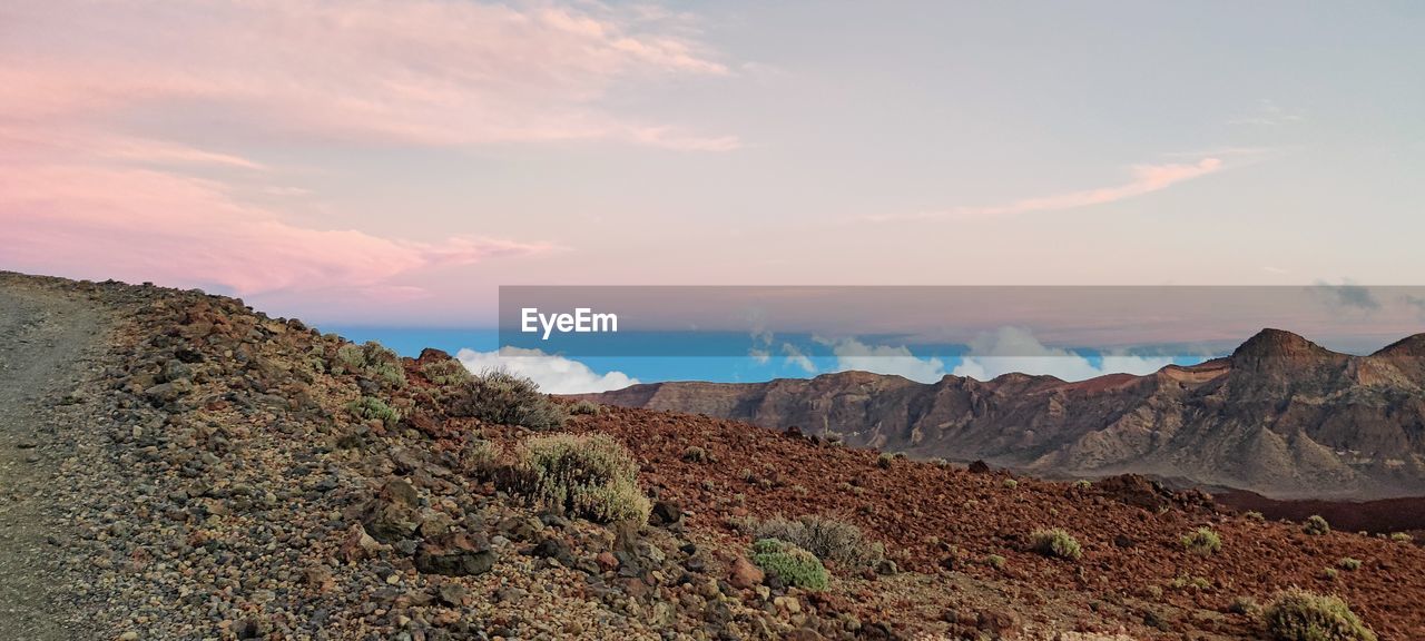Scenic view of volcanic mountains against sky during sunset