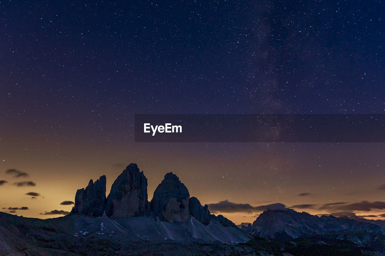 Scenic view of snowcapped mountains against sky at night