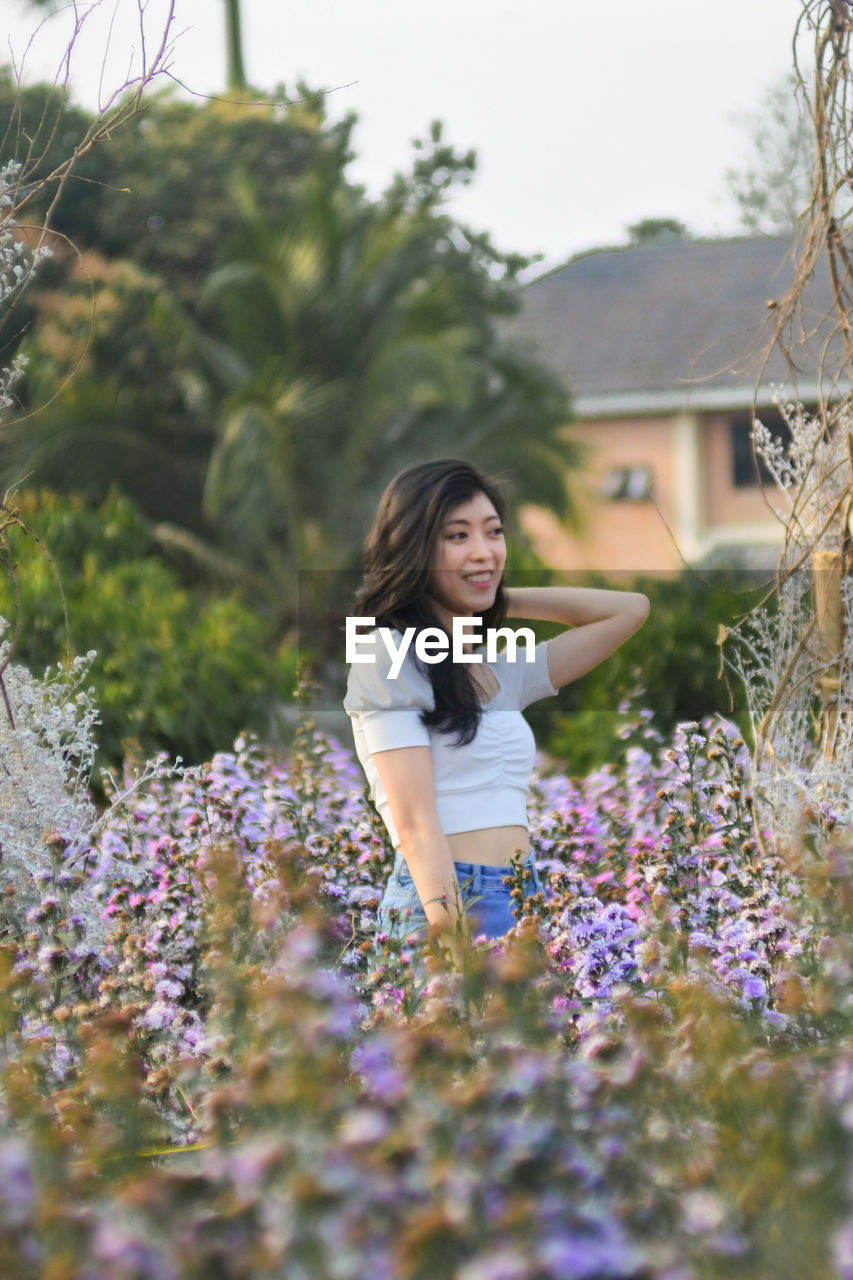 Young woman standing on flowering plants