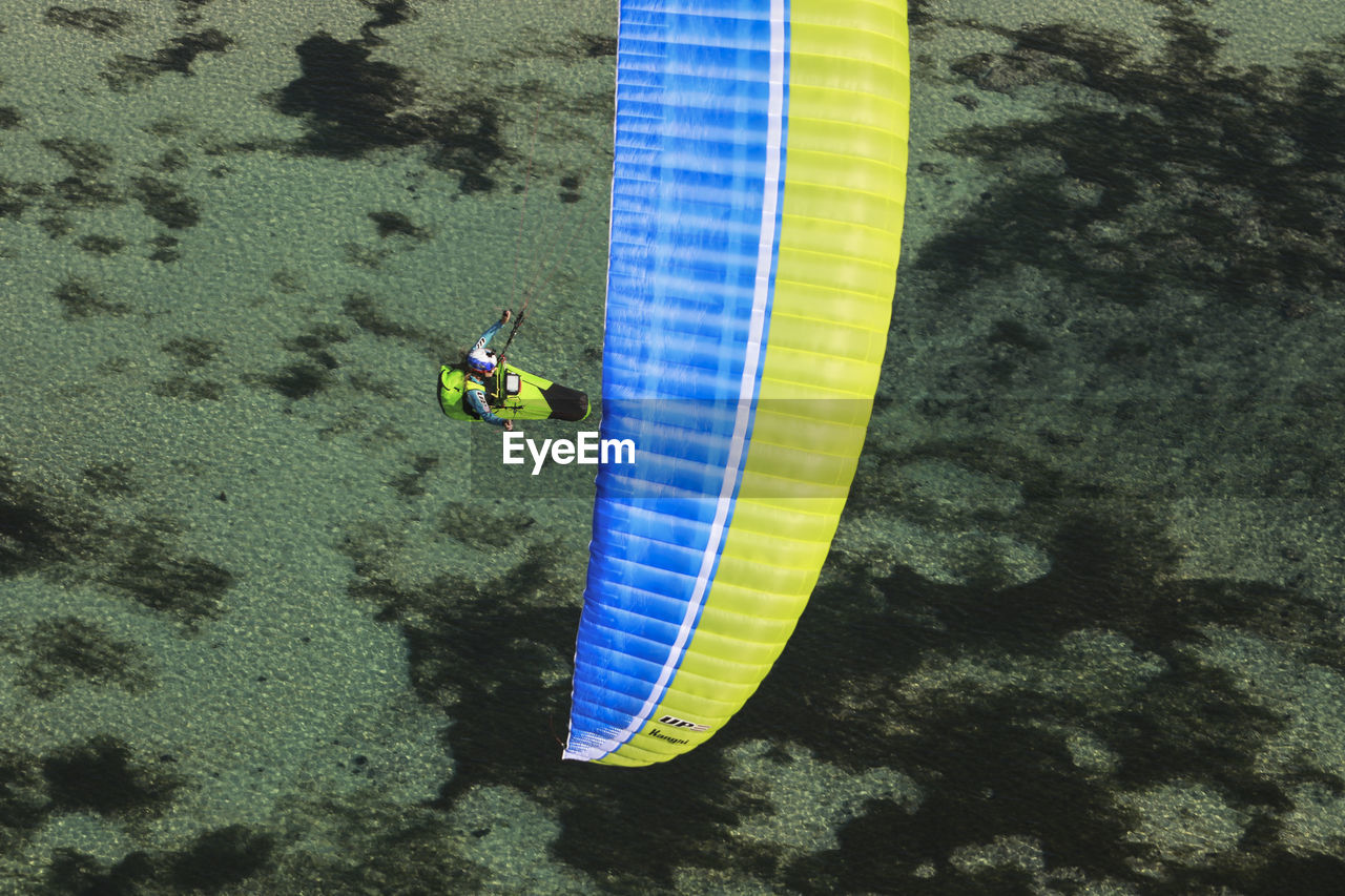 HIGH ANGLE VIEW OF MAN AND YELLOW UMBRELLA