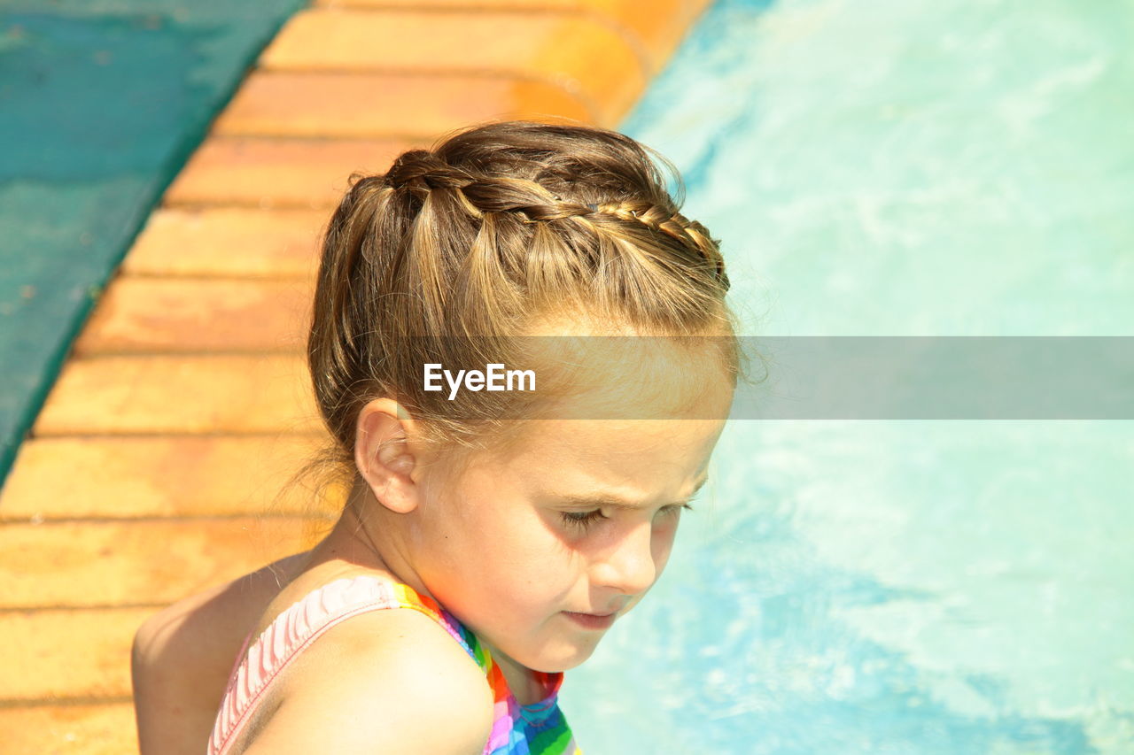 Close-up portrait of girl looking at swimming pool