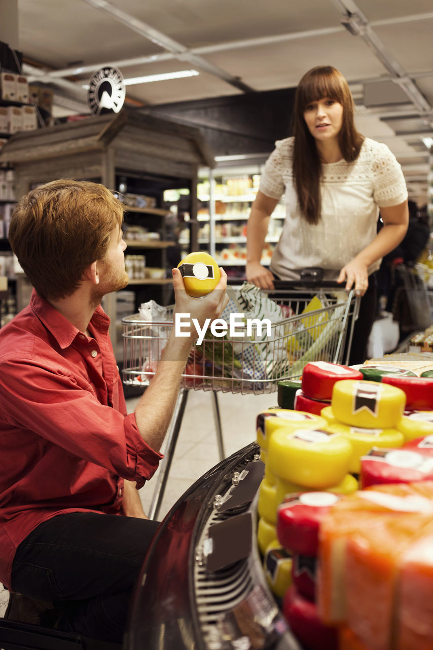 Couple shopping cheese at supermarket