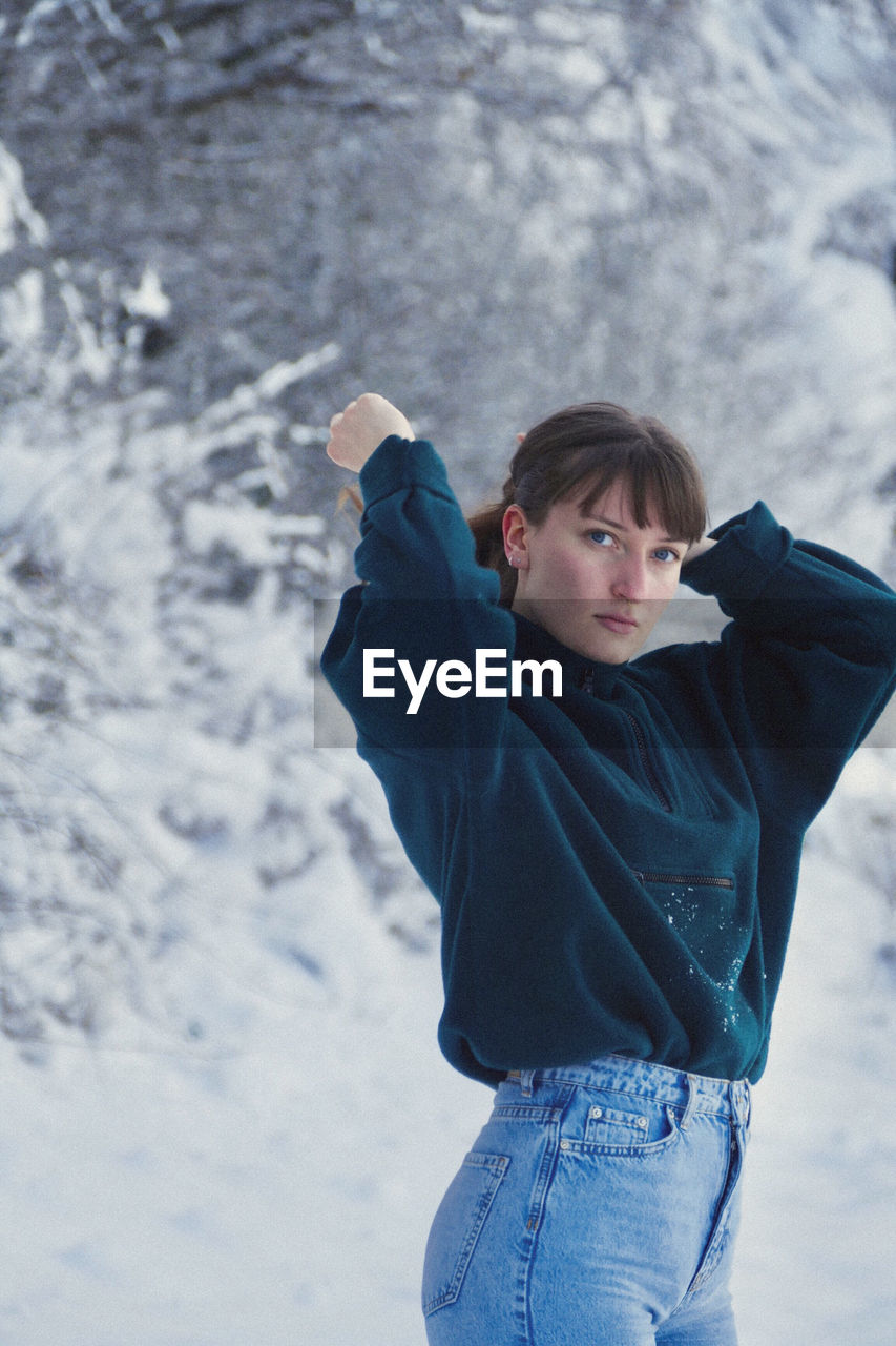 Portrait of young beautiful woman, waist up, standing in snow